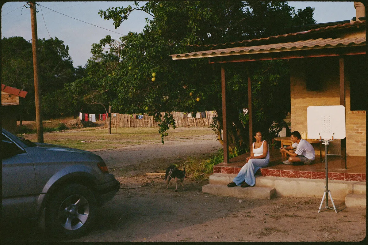 Família na varanda de um sítio com a picape no terreiro