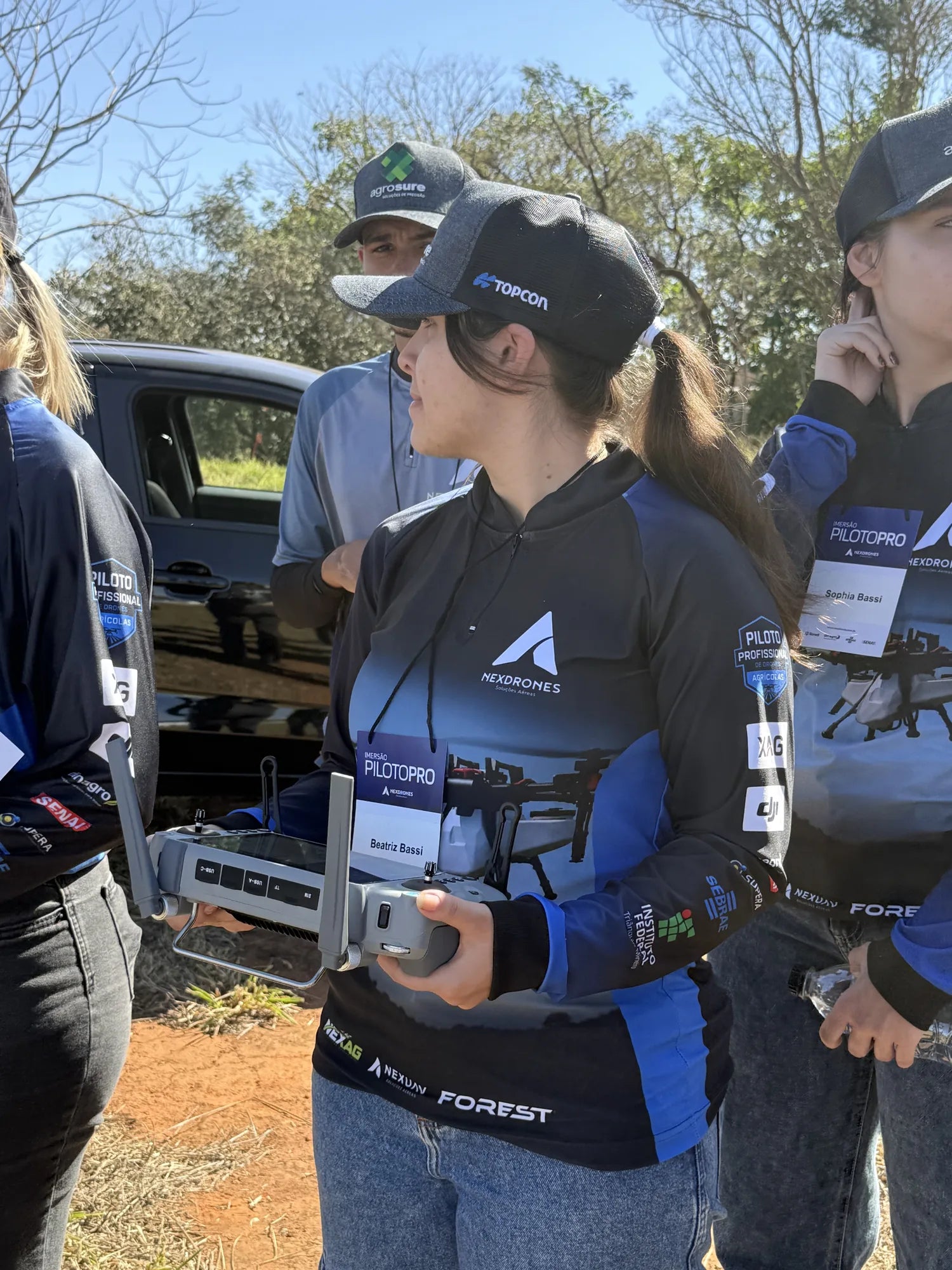 Participante da Imersão Piloto PRO com o controle do drone agrícola nas mãos